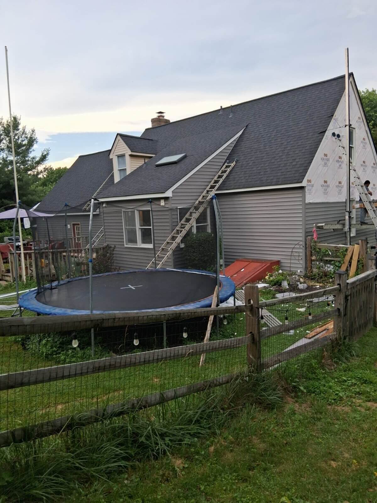 House with trampoline and ladders outside.