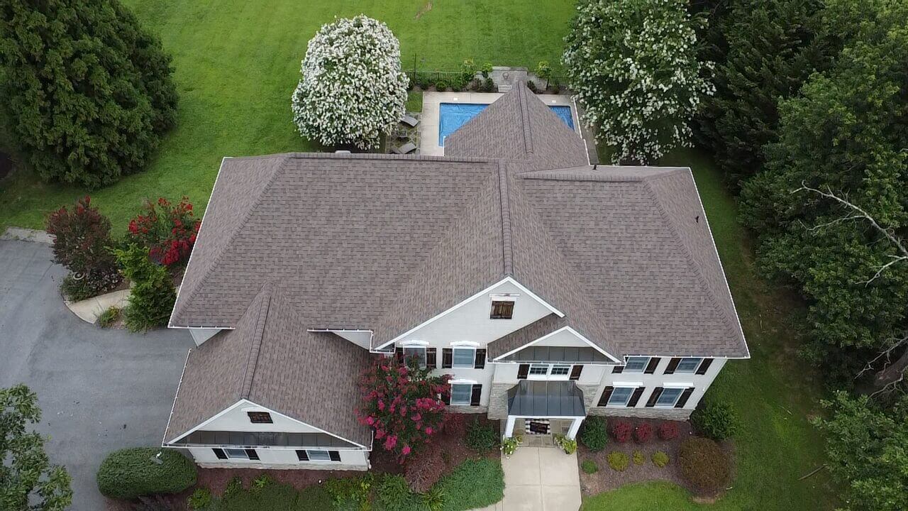 Aerial view of house with backyard pool.