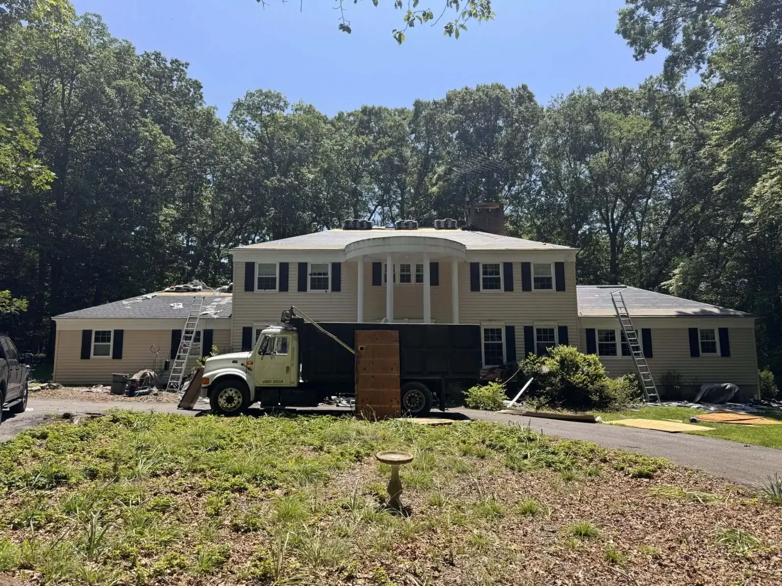 Two-story house with roofers and truck